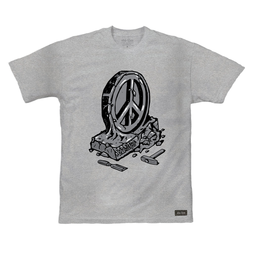 100% Ringspun Cotton Tee with a peace sign carved into rock. Hand screen printed in Santa Cruz CA with eco friendly water base inks. Custom shalom definition neck tag and shalom definition woven label sewn on the bottom left corner. Wear this garment in peace. Shalom Peace Every-Wear. 